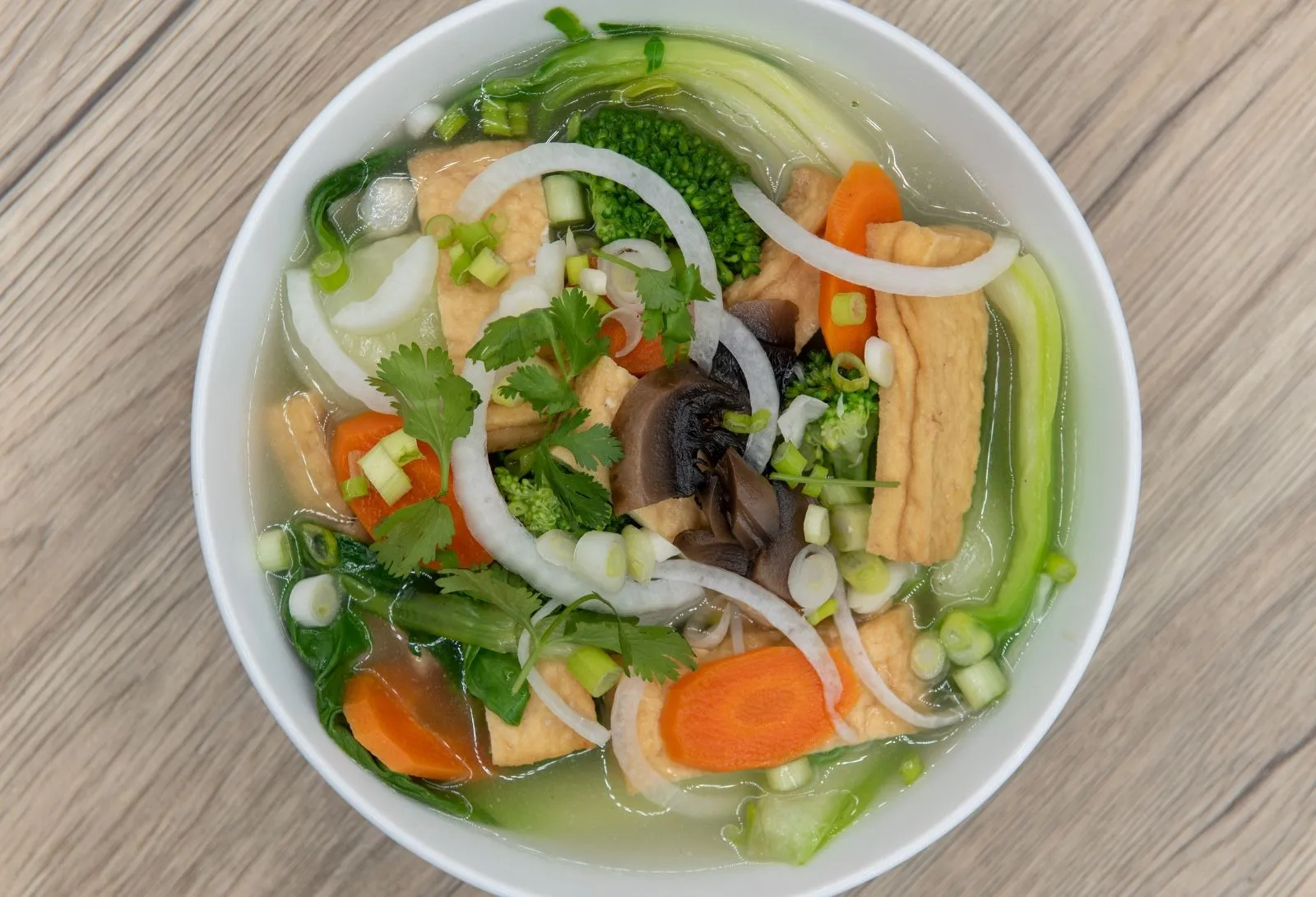 Clear vegetable tofu soup with bok choy, mushrooms, carrot and fresh herbs at Pho Kitchen, a Vietnamese Restaurant in San Jose