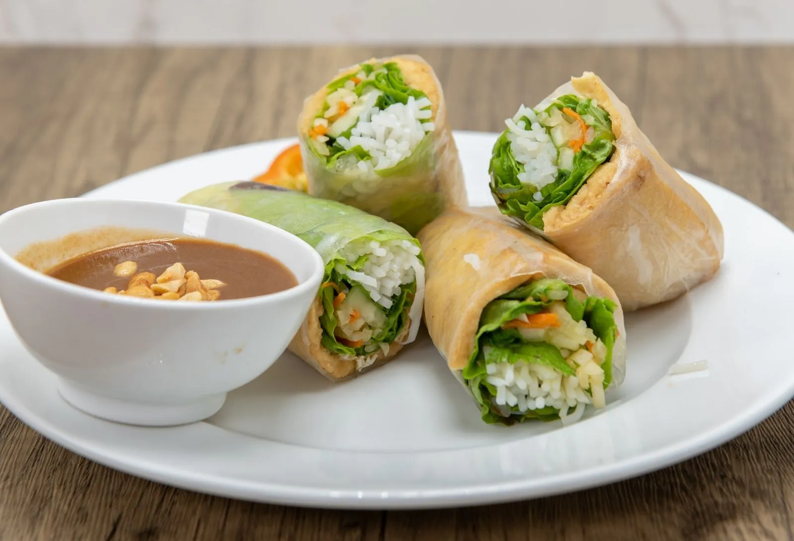 Four fresh rice paper spring rolls served with creamy peanut dipping sauce at Pho Kitchen, a Vietnamese Restaurant in San Jose